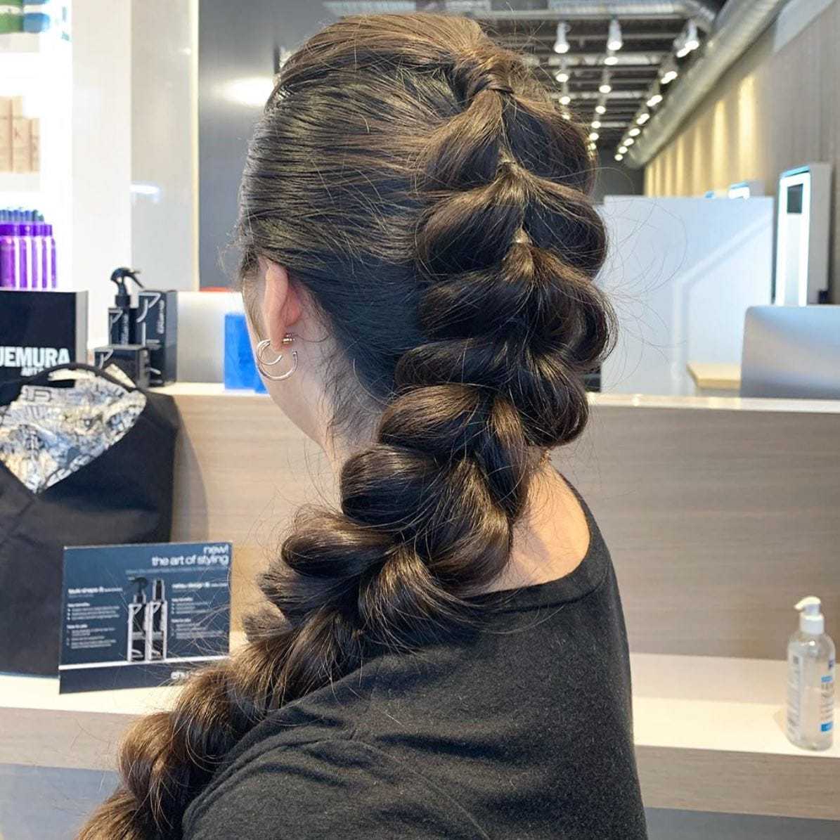 Woman with a voluminous braid hairstyle in a modern hair salon.